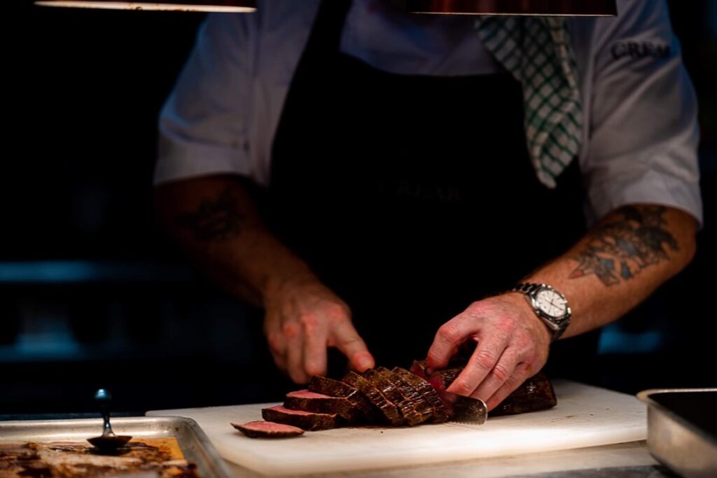 Big Bite Catering me slicing beef fillet under the lights